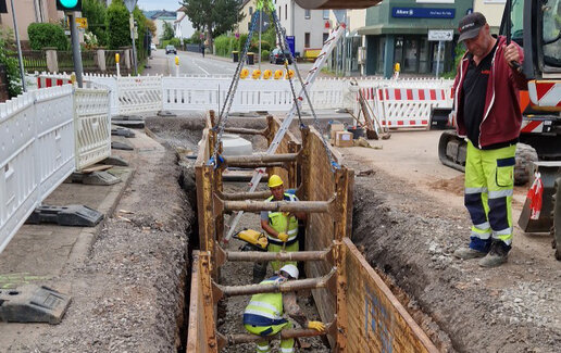 Ingenieure besprechen Tiefbaupläne über Bauzeichnungen hinweg